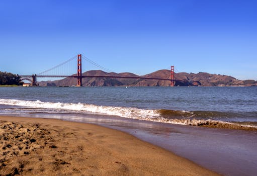 Scenic view of the Golden Gate Bridge from a sandy beach in San Francisco, California.