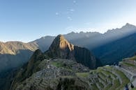 Dramatic aerial view of Machu Picchu with sunrays, capturing its ancient beauty and mountainous landscape.
