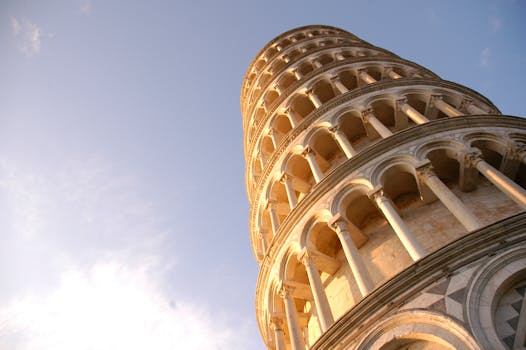 Low angle view of the Leaning Tower of Pisa, a famous Italian landmark under a clear sky.